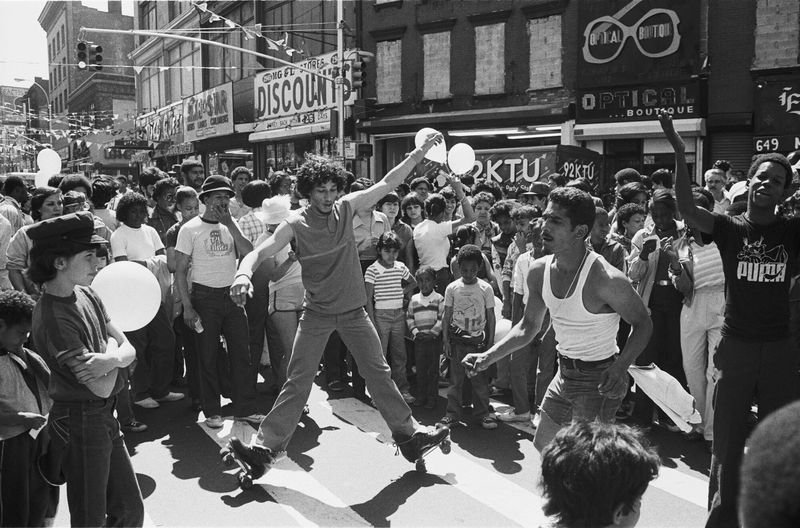 Breakdancers on a Bronx street with crowd watching, early hip-hop era 1980s