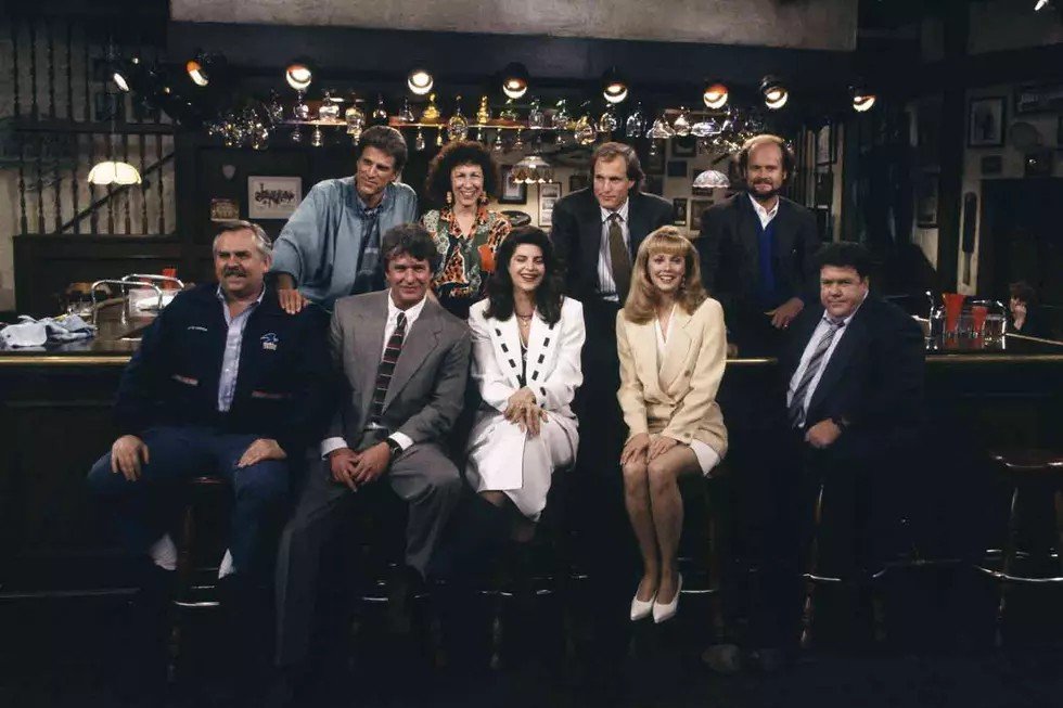 The Cheers cast seated together at the bar set in a later season photo