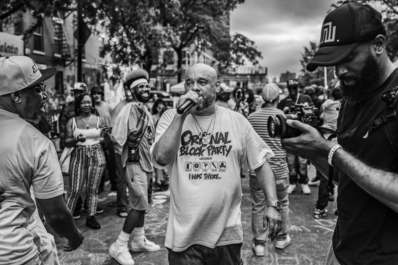 Performer at the 2023 Hip-Hop 50th Anniversary block party wearing Original Block Party Member shirt