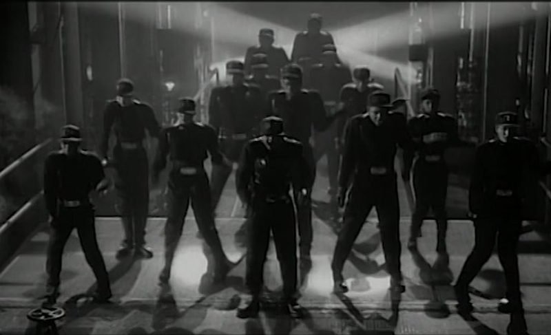 A dramatic warehouse scene from the Rhythm Nation 1814 music video