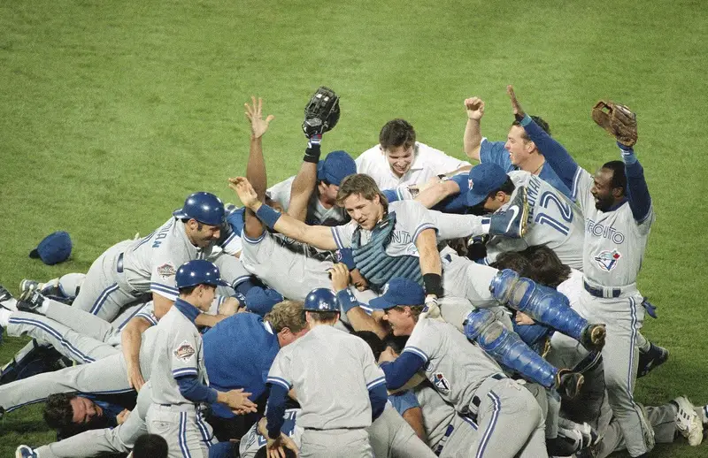 Toronto Blue Jays players pile on top of each other celebrating the 1992 World Series championship