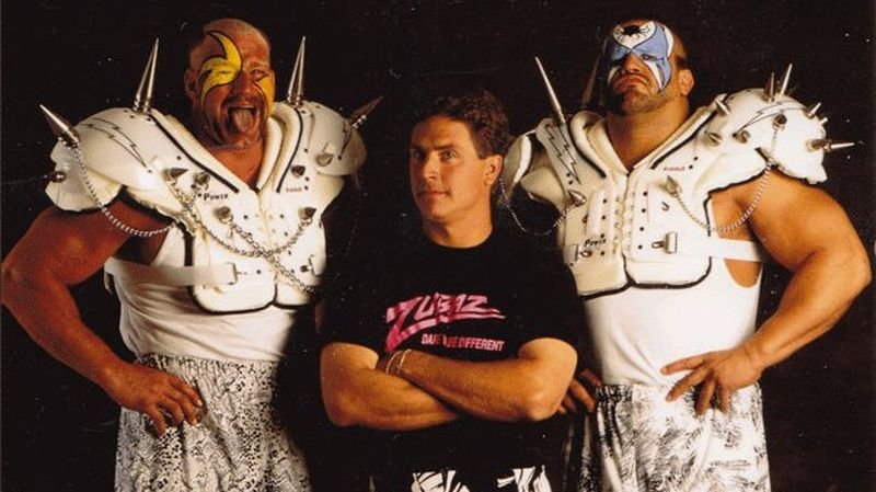Road Warriors Hawk and Animal posing with Zubaz co-founder wearing a branded Zubaz t-shirt