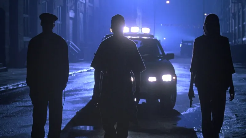 Silhouetted figures in a tense nighttime street scene from the 1994 film Fresh