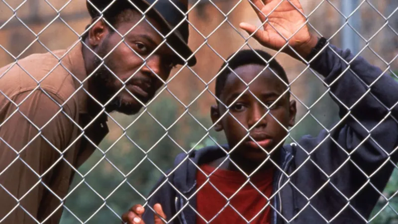 Samuel L. Jackson and Sean Nelson share a father-son moment through a fence in Fresh 1994