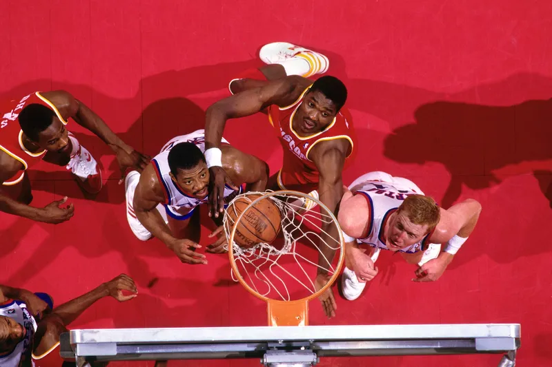 Hakeem Olajuwon battles for a rebound under the rim with Houston Rockets teammates during his early NBA career