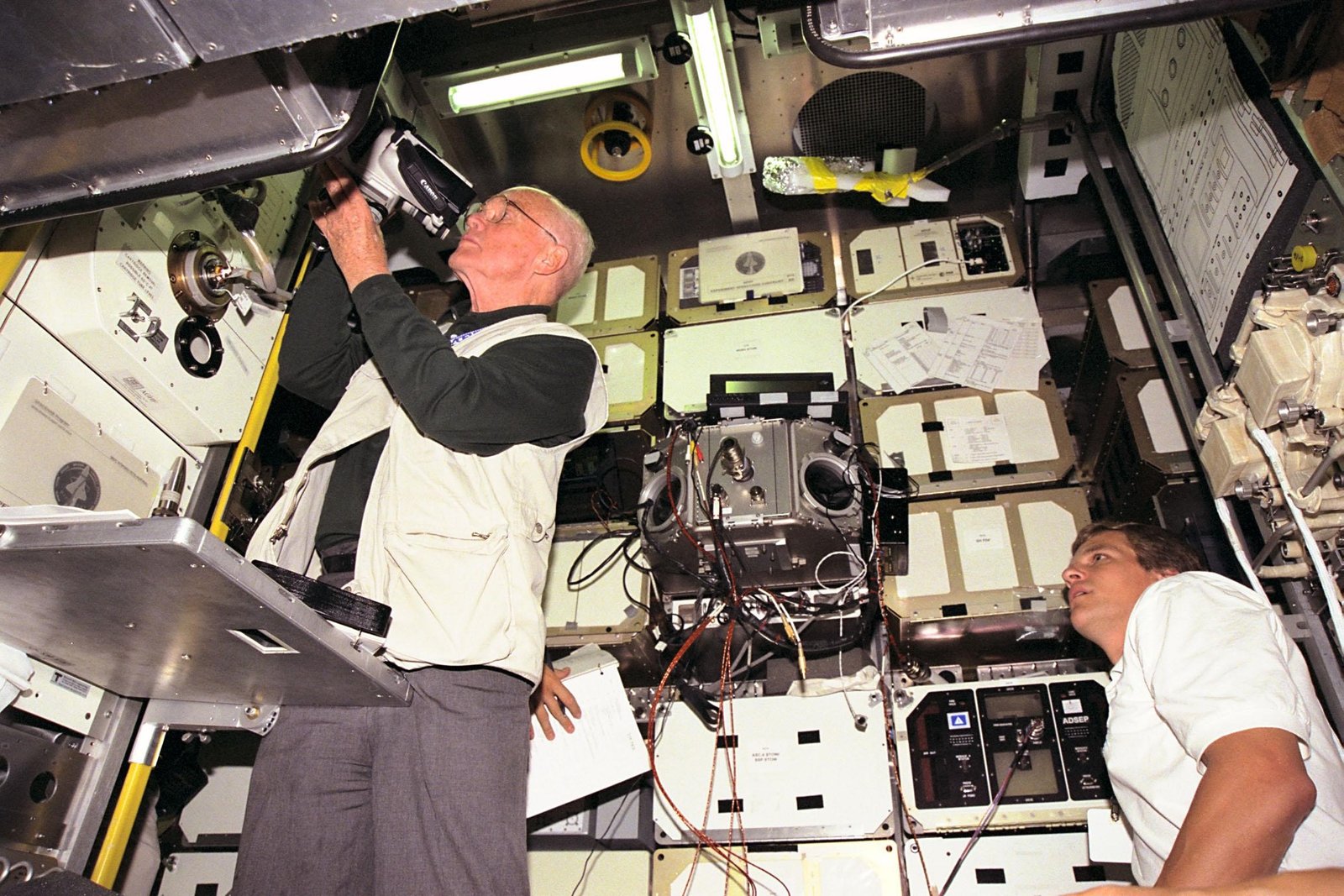 John Glenn working with equipment inside the SPACEHAB trainer during STS-95 mission preparation in 1998
