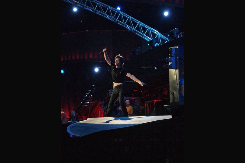 Mick Jagger performing live on stage with arms outstretched