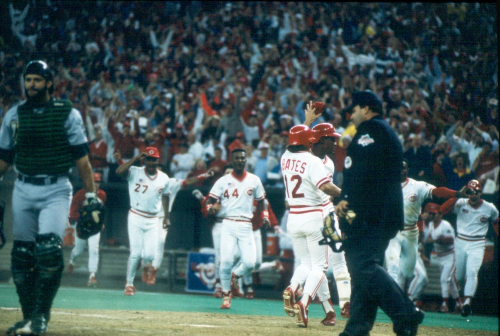 Cincinnati Reds players celebrate at home plate during 1990 World Series