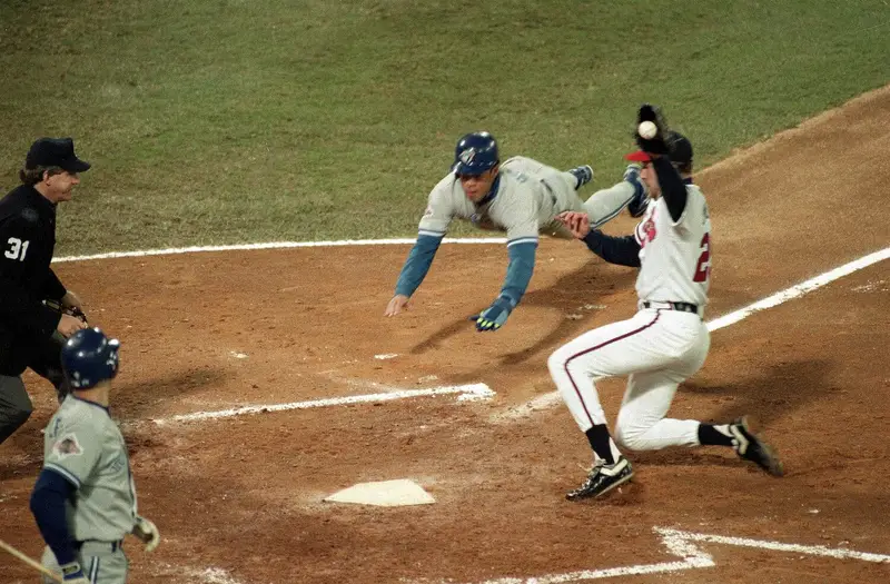 Roberto Alomar dives for home plate during a 1992 World Series game against the Atlanta Braves