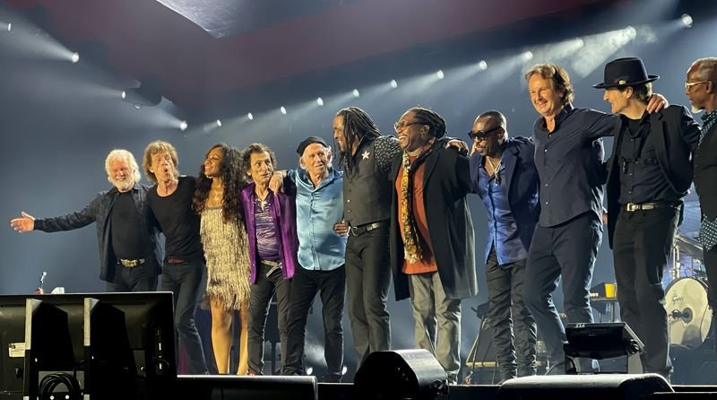 The Rolling Stones taking a bow together on stage at the end of a concert